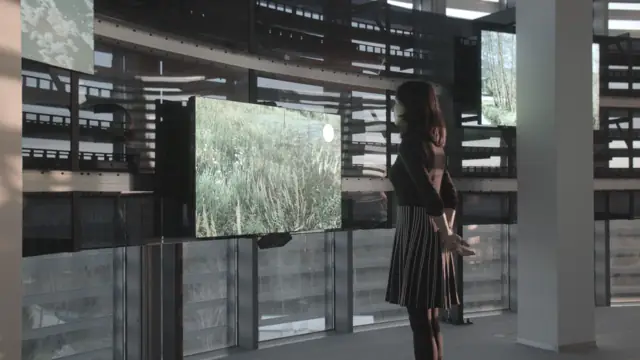 A visitor in front of a screen on rails